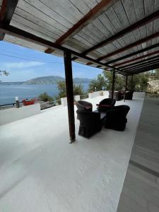 a patio with chairs and a table and a view of the ocean at Marios Rooms in Vlorë