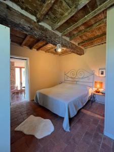 a bedroom with a white bed in a room at Tenuta Il Colle di Tiglio in Barga