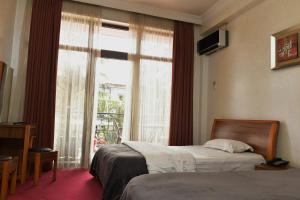 ein Hotelzimmer mit 2 Betten und einem Fenster in der Unterkunft Antika Hotel in Batumi
