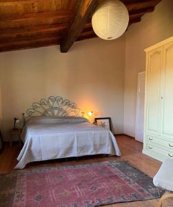 1 dormitorio con cama y alfombra en el suelo en Tenuta Il Colle di Tiglio, en Barga