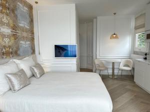 a bedroom with a white bed and a table at Appartamento Aria del Mare in Ventimiglia +14 photos