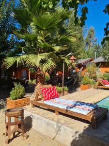 1 cama con almohadas rojas y blancas junto a la piscina en Cabañas Refugio Nativo, en Santa Cruz