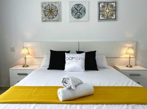 ein Schlafzimmer mit einem weißen Bett und einem Handtuch darauf in der Unterkunft Domuum Holidays - BARCELONA Family Home in Salou