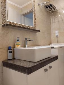 a bathroom with a white sink and a mirror at Villa George Sea View with pool - Triopetra in Triopetra