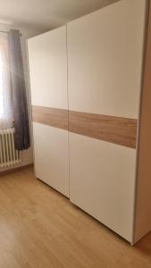 a room with a large white cabinet with wood trim at Schöne 2-Zimmer Ferienwohnung in Löffingen