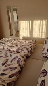 Una cama con edredón y una almohada. en Schöne 2-Zimmer Ferienwohnung en Löffingen