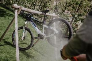 una bicicleta está enganchada a una valla de madera en Feldgärtenhof en Silandro