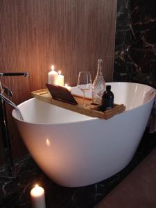 a bath tub with candles and a glass of wine at ZB Apartment Luxor Bobrowniki Rogożnik Pyrzowice 