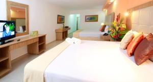 a hotel room with a large bed and a television at Hippocampus Vacation Club in Pampatar