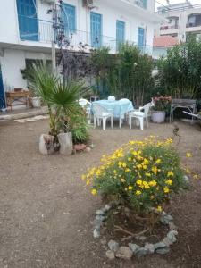 einen Garten mit einem Tisch, Stühlen und Blumen in der Unterkunft hantra thalasia 1 in Poros