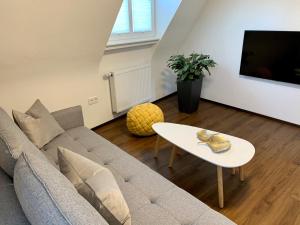 a living room with a couch and a table at Apartment im alten Rathaus in Malterdingen