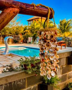 a bunch of shells hanging on a wall next to a swimming pool at Flats Macapá Meu Amor 4 in Luis Correia