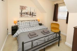 a bedroom with a bed and a chair at 3Bed/2Bath Duplex Apartment - Pure Bliss Belfast in Belfast