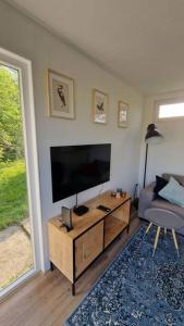 a living room with a flat screen tv and a couch at Tiny house ''De Veenpolder'' in De Veenhoop