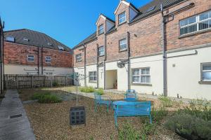 a yard with two blue chairs in front of a building at 3Bed/2Bath Duplex Apartment - Pure Bliss Belfast in Belfast
