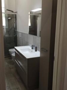 a bathroom with a sink and a toilet and a mirror at AFFITTACAMERE S.ORSOLA - MALPIGHI in Bologna