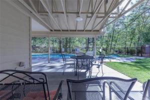 a covered patio with tables and chairs and a pool at Condo at Slide Creek in Bass Lake