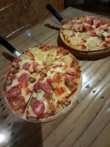 two pizzas sitting on top of a wooden table at El Delfin in Zorritos