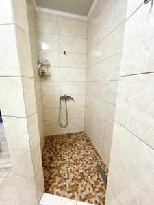een badkamer met een douche en een tegelvloer bij Просторная двухкомнатная квартира с видом на море в Аркадии! in Odessa