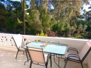 a patio with a table and chairs on a balcony at Apartment 50m from sea! in Xylokastron