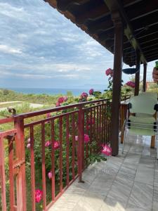 een balkon met uitzicht op de oceaan en de bloemen bij Real Holidays Antoniadou - Rustic House in Elaiokhórion