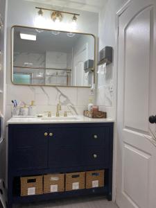 bagno con lavandino e grande specchio di Modern Loft 