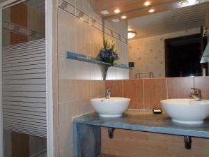 Baño con 2 lavabos blancos en una encimera en Domaine des Escouanes en Prudhomat