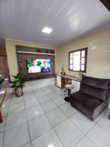 sala de estar con sofá y TV de pantalla plana en La Casa de Gramado, en Gramado