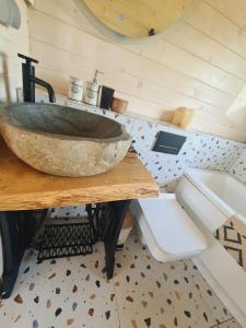 a bathroom with a stone sink on a table at Cuda Wianki in Zdów