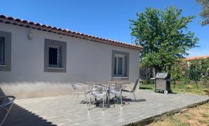 une terrasse avec des chaises et un barbecue en face d'une maison dans l'établissement Magnifique Villa idéalement située, à Puget-sur Argens