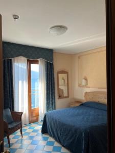 - une chambre avec un lit bleu et une fenêtre dans l'établissement Hotel Locanda Ruscello Garnì, à Limone sul Garda