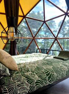 een bed in een kamer met een groot raam bij Glamping Zarasai in Palivarkas