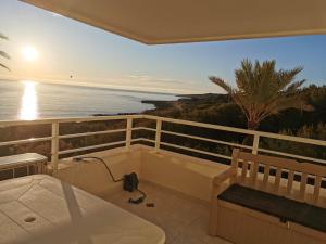 einen Balkon mit Blick auf das Meer bei Sonnenuntergang in der Unterkunft Family Sun Seasight Apartment in Cala Millor
