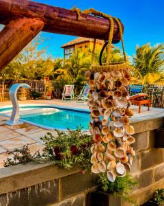 un montón de conchas colgando en una pared junto a una piscina en FLATS MACAPÁ MEU AMOR 6 en Luis Correia