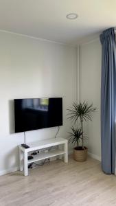 een woonkamer met een tv en een witte tafel bij Studio apartment 2 in Pärnu
