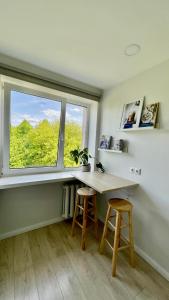 een kamer met een bureau, een raam en 2 krukken bij Studio apartment 2 in Pärnu