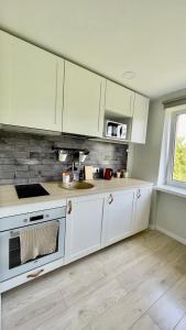 een keuken met witte kasten en een wastafel bij Studio apartment 2 in Pärnu