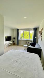 a bedroom with a bed and a couch and a television at Studio apartment 2 in Pärnu