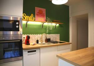 eine Küche mit Spüle und Herd oberen Backofen in der Unterkunft L'Eden Chic - Balneo - Jardin - Parking gratuit in Arras + 34 Fotos