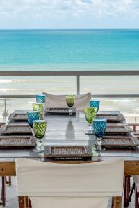 a dining table with a view of the ocean at DELUX PRAIA Flats in Natal