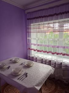 a table with a white table cloth and a window at Гостиница Энглер в Хромтау in Khromtaū