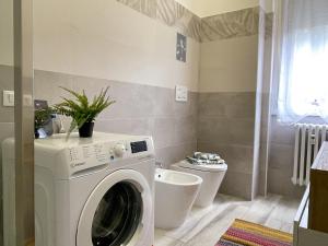 a washing machine in a bathroom with a toilet at Bnbook Lattuada 3 camere da letto 2 bagni in Rho