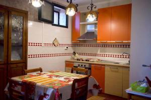 eine Küche mit einem Tisch und eine Küche mit orangefarbenen Schränken in der Unterkunft Casa Salitto San Michele in Olevano sul Tusciano
