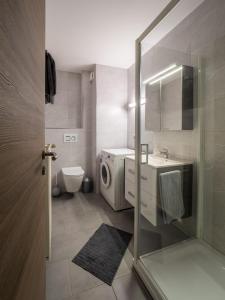 ein Badezimmer mit einem Waschbecken und einer Waschmaschine in der Unterkunft A Mëchels in Bettel