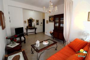 福洛尼卡的住宿－Maremma Holidays : Fiore Apartment，客厅配有橙色沙发和桌子