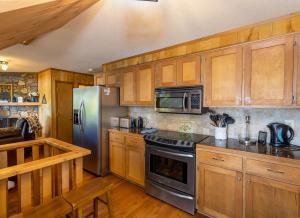 eine Küche mit Holzschränken und einem Kühlschrank aus Edelstahl in der Unterkunft Beary Blessed Cabin in Fleetwood