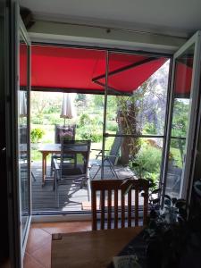 a screened in porch with a red umbrella at Ferienhaus Liwi in Liessow