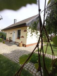una pequeña casa blanca con entrada de ladrillo en Ferienhaus Liwi, en Liessow
