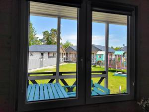a window with a bench looking out at a playground at Pastelowe Borne in Borne Sulinowo