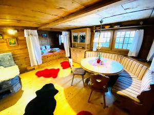 Zimmer mit einem Tisch und einem Sofa sowie einem Schlafzimmer in der Unterkunft Zum Stillen Unicum in Axalp